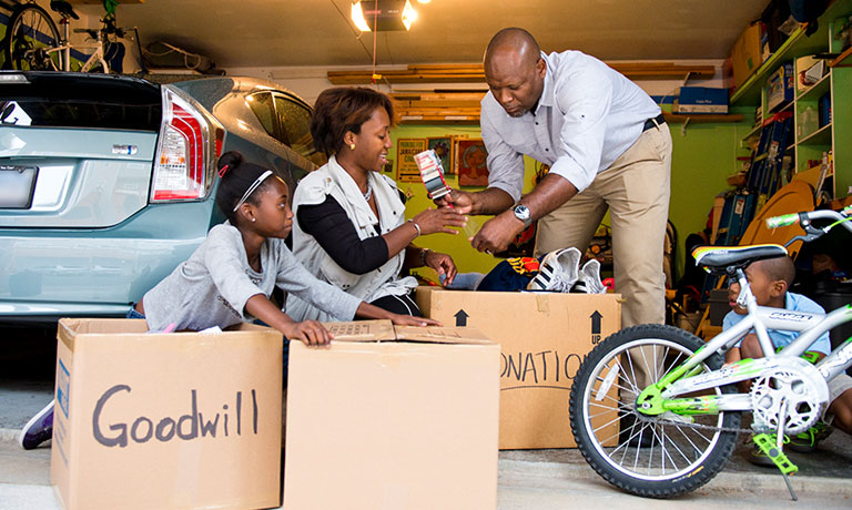 a young family packs items for donation in their garage