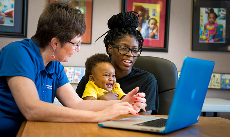 a young woman and her infant son meet with Goodwill team member for family services