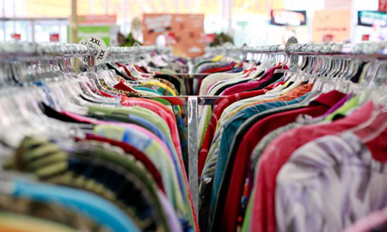 close up view of two clothing racks with shirts on hangers